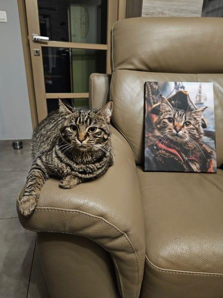 Chat tigré sur un canapé à côté de son portrait imprimé